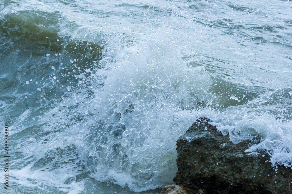 Fototapeta premium pebble stones on the sea beach, the rolling waves of the sea with foam