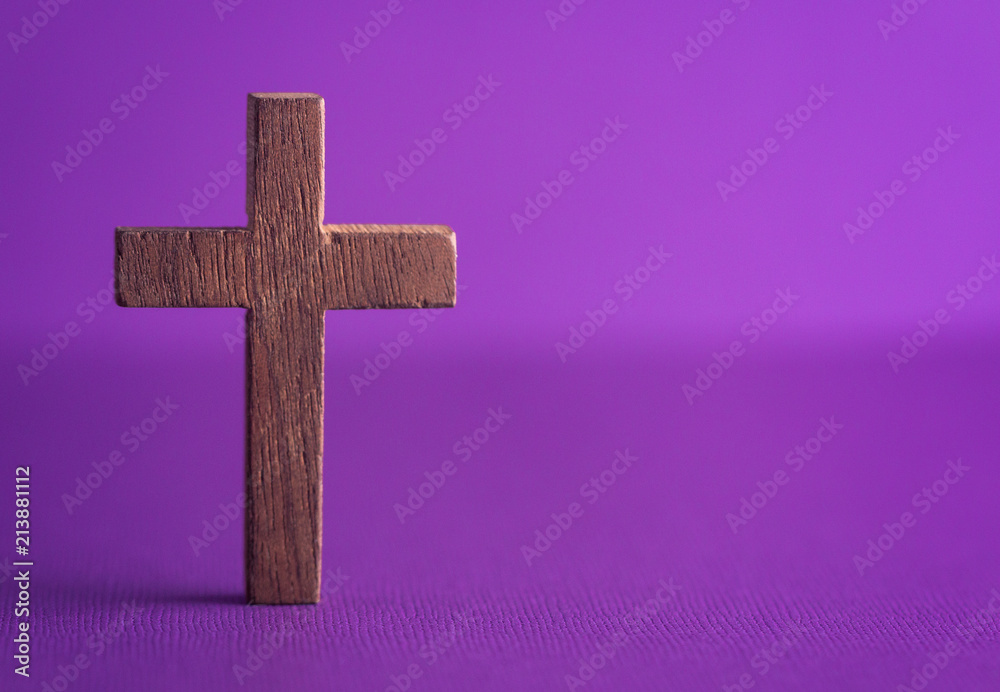 A Simple Wooden Cross on a Purple Background