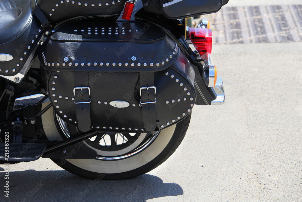 Ταπετσαρία Close up of a black leather strapped and studded motorcycle pannier or bag, on a
