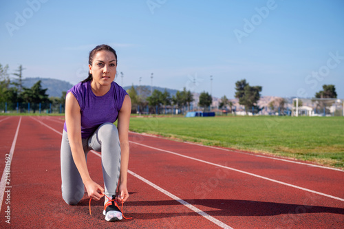 Young woman runner tying shoelaces. Exercise concept.