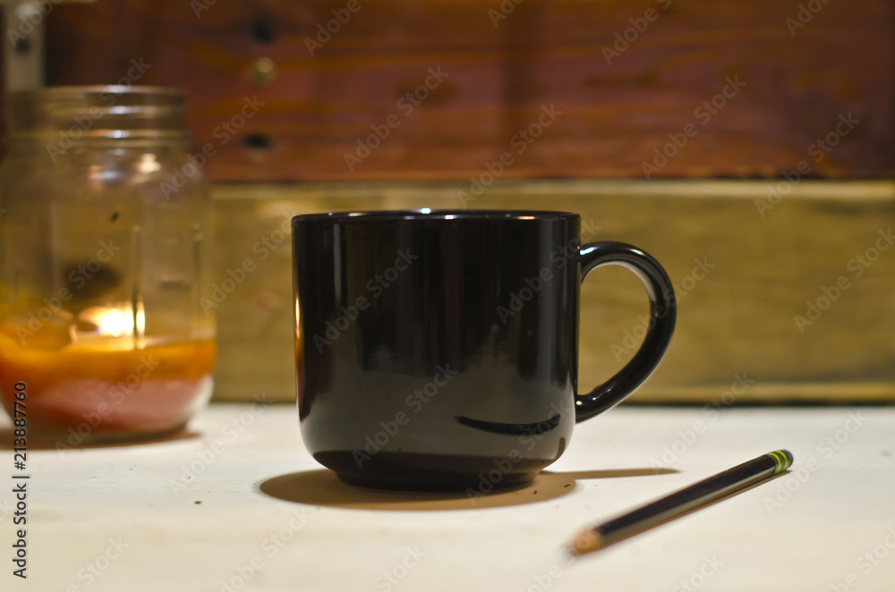 A blank black coffee mug on the old shop work bench in the morning light. A blank black coffee mug on the old shop work bench in the morning light.