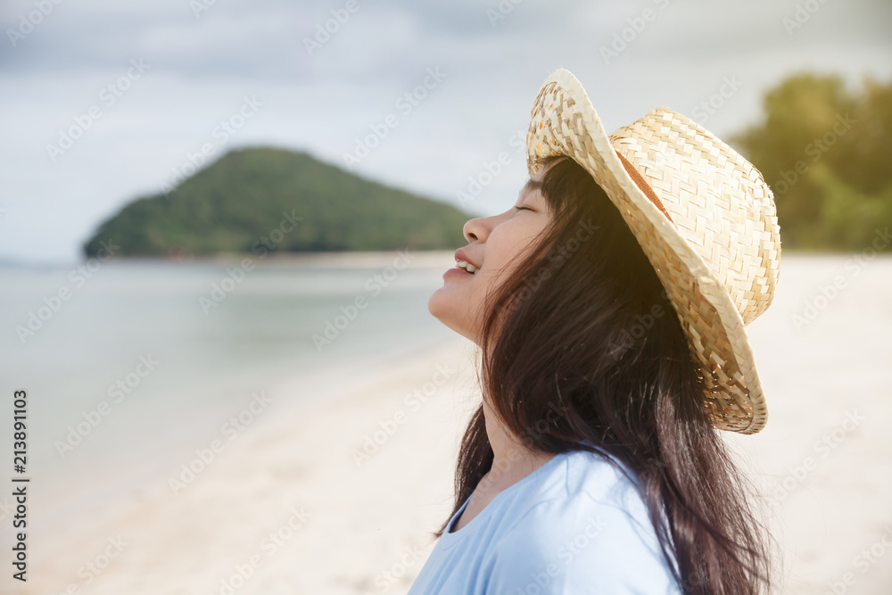 Woman with straw hat at the beach.
