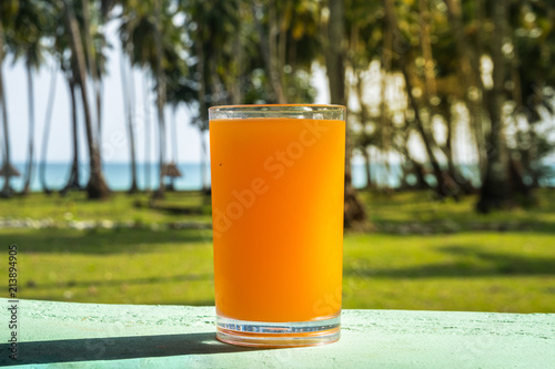 A glass of orange juice is placed photo