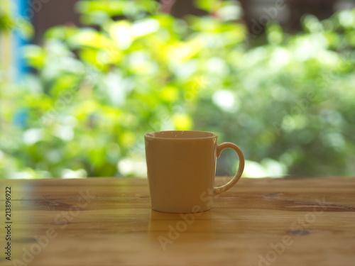 Closeup White Cofee Cup with Green leaf bokeh.