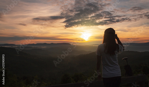 Billede på lærred Girl with a sunset on a hilltop