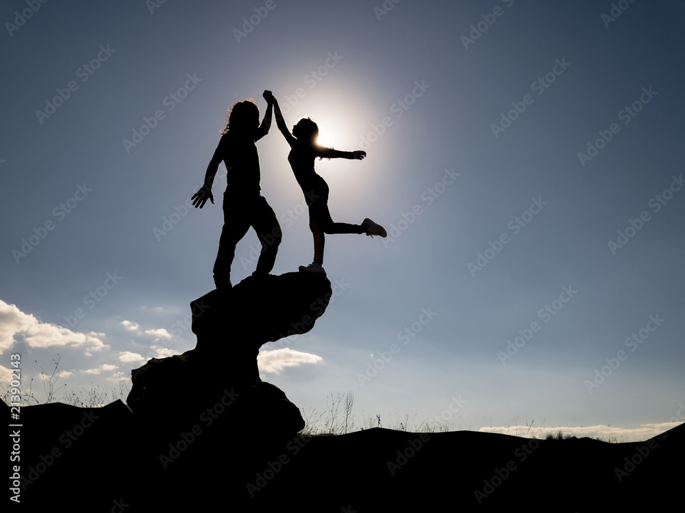 young couple success;athletic boy and slim girl standing with raised arms on rocky mountain top enjoying breathtaking summer mountain view. Tourism, traveling and healthy lifestyle concept young couple success;athletic boy and slim girl standing with raised arms on rocky mountain top enjoying breathtaking summer mountain view. Tourism, traveling and healthy lifestyle concept