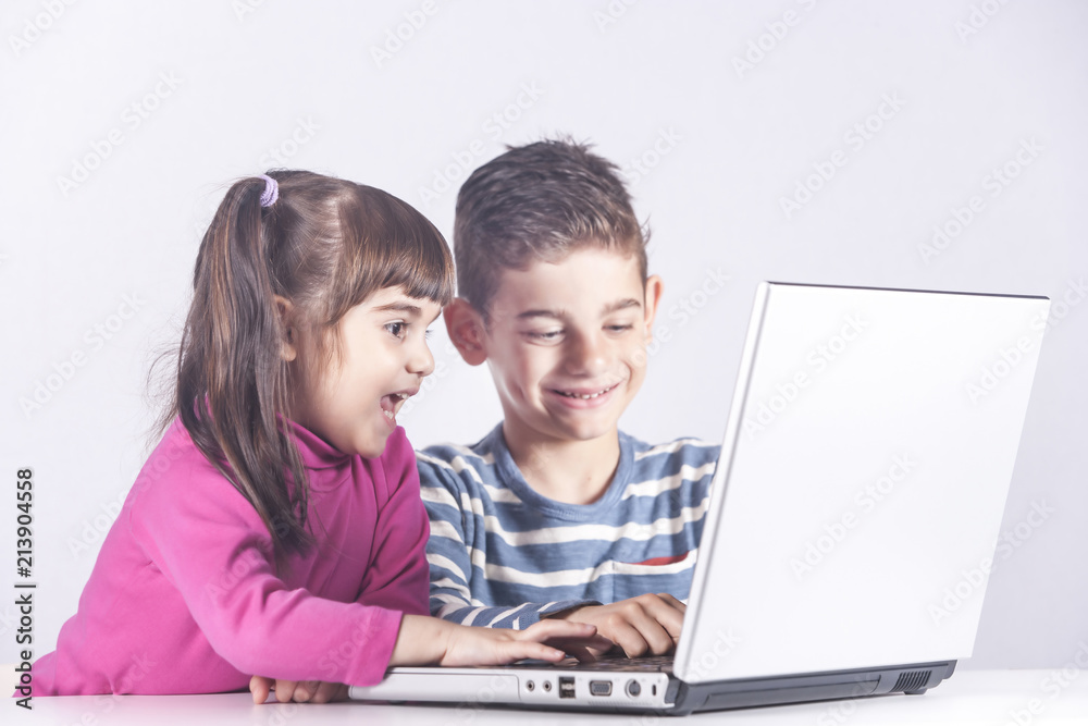 Kids having fun using a laptop computer. Education, technology and e-learning concept Kids having fun using a laptop computer. Education, technology and e-learning concept