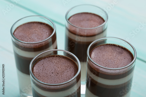 four glasses with chocolate dessert close-up, on a turquoise background, the concept of a feast and dessert