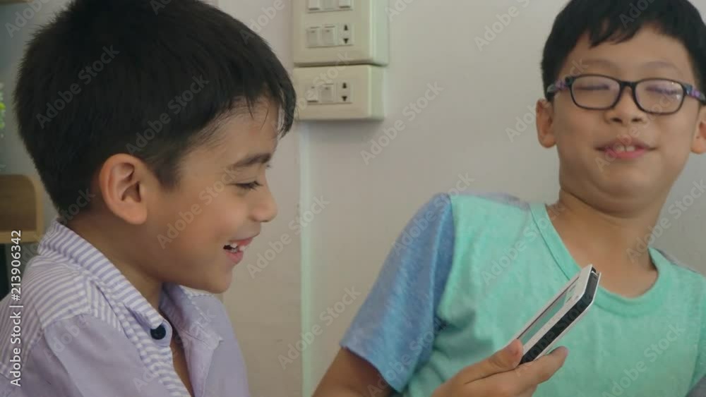 Asian boys playing games on tablet computer Asian boys playing games on tablet computer