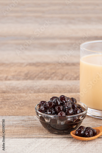 Tapioca Pearl   Bubble topping for tea or other beverage  in a cup  place on wooden table. Copy space