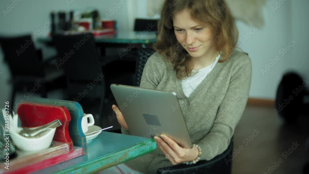 Young woman enjoys a tablet in a cafe bar Young woman enjoys a tablet in a cafe bar