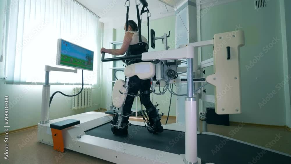 Paraplegic patient is practicing walking on a special simulator. Virtual reality simulator for patient rehab. Paraplegic patient is practicing walking on a special simulator. Virtual reality simulator for patient rehab.