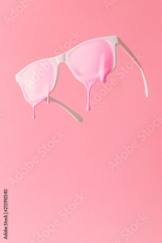 Fototapeta Pink paint dripping out of white painted sunglasses. Creative fashion minimal concept.