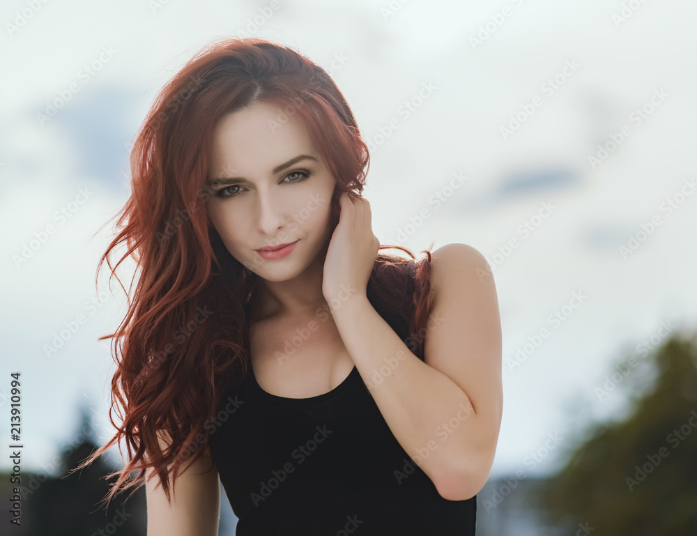 Portrait of attractive red haired young woman with blue eyes.