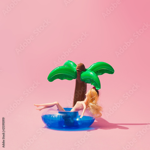 Fototapeta Nadmuchiwana zabawka tropikalnej palmy z lalką na różowym tle. Koncepcja lato kreatywnych minimalne piękno.