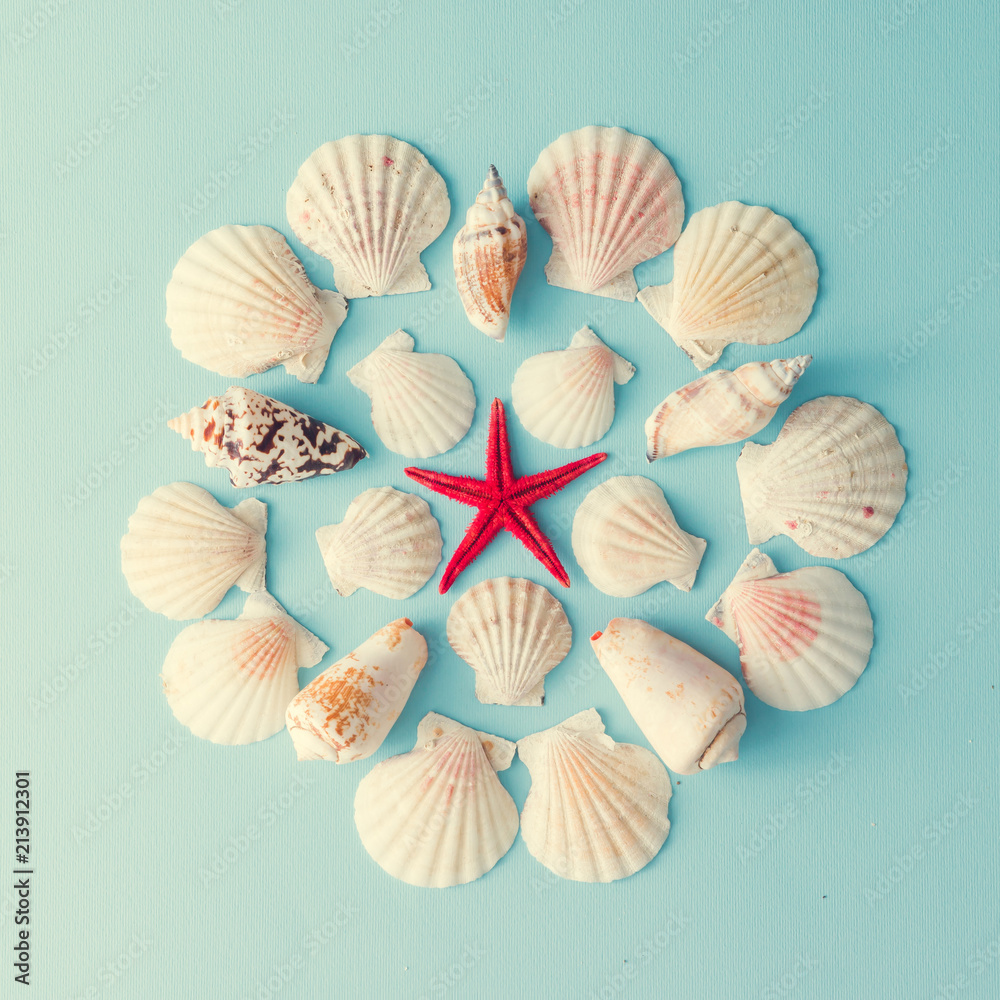 Creative seashell pattern with red starfish on blue background. Summer flat lay. Creative seashell pattern with red starfish on blue background. Summer flat lay.