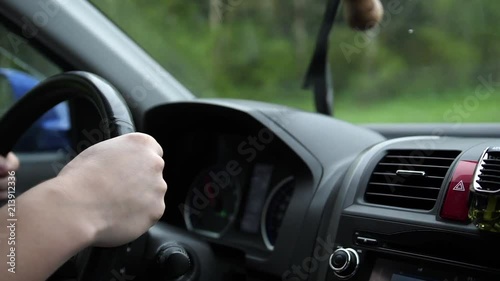 Family trip. The family is driving on the highway. There is a small rain, the windscreen wipers operate