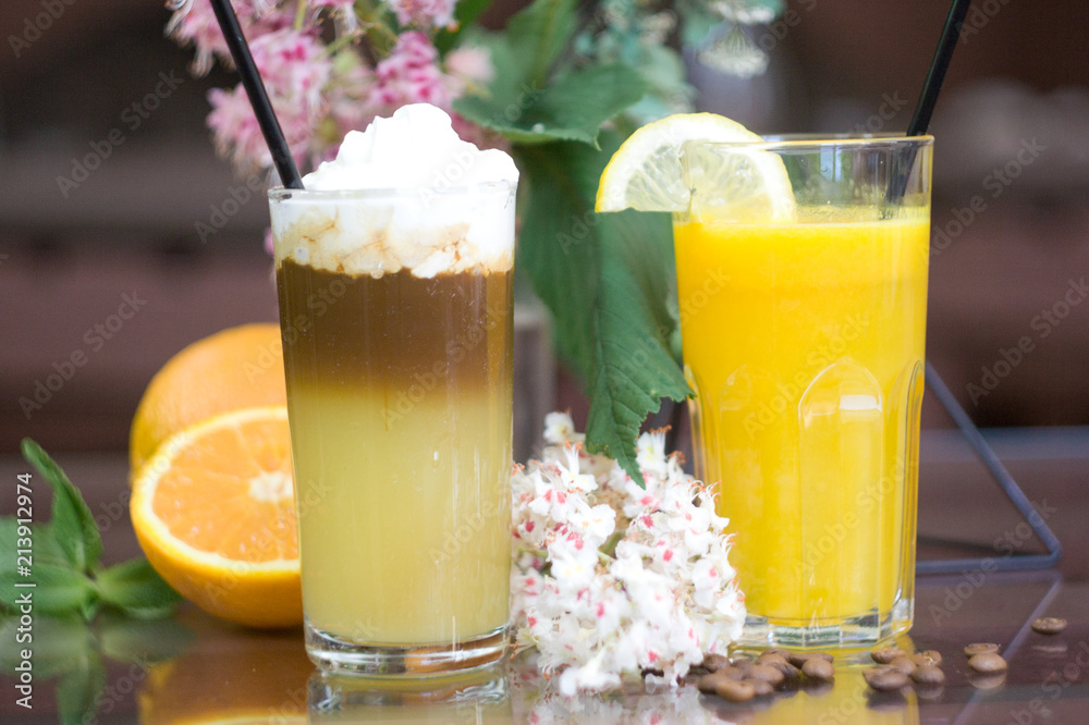 Glasses with fresh orange juice and coffee cocktail on table. Glasses with fresh orange juice and coffee cocktail on table.