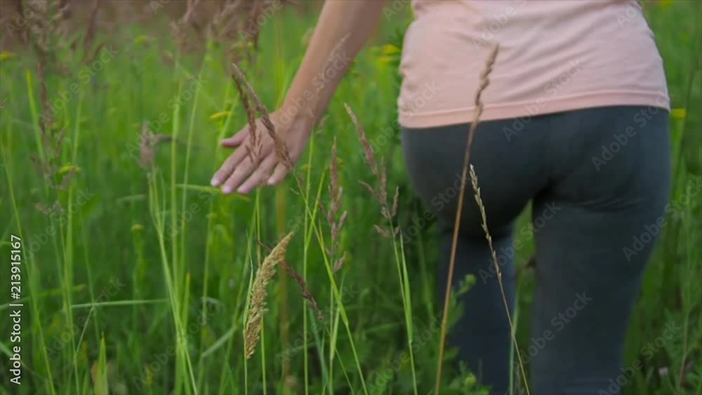 Beautiful woman walking outdoors in flowering field, slow motion video Beautiful woman walking outdoors in flowering field, slow motion video