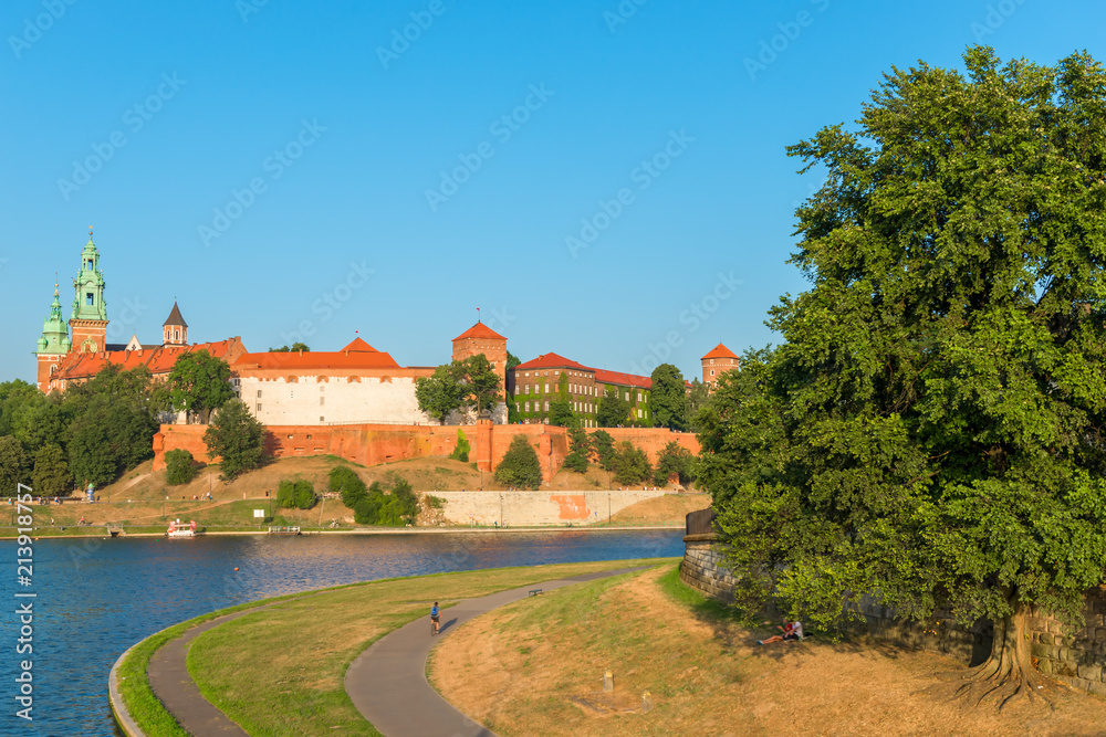 Obraz premium Krakow, Poland - August 11, 2017: beautiful park and panorama of Wawel Castle on the bank of the Wisla River