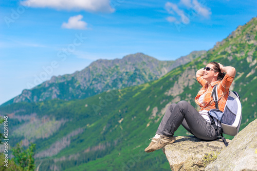 A tourist with a backpack on the background of beautiful mountains relaxes