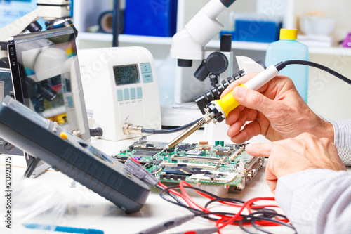 hand men hold tool repairs electronics manufacturing
