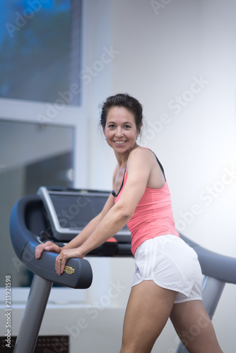 attractive sport woman on running track. Girl with a smile on treadmill