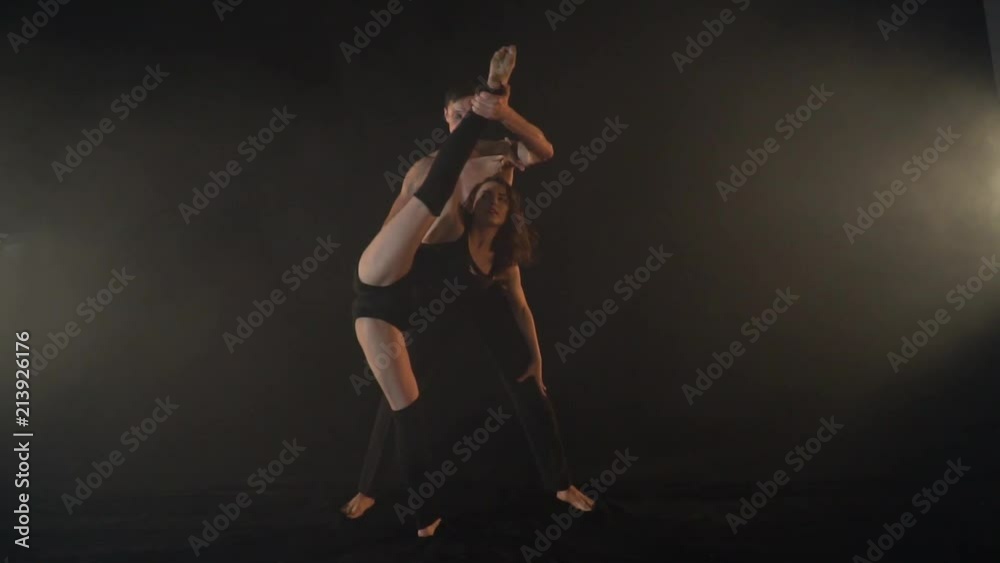 Slow shooting, a couple of acrobats, a man helps to make a twine and a flip Slow shooting, a couple of acrobats, a man helps to make a twine and a flip