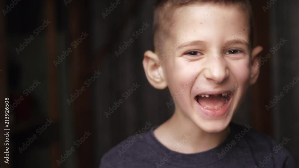 Cute boy looking at camera and laughing. Missing several front teeth. Real sincere emotions. Cute boy looking at camera and laughing. Missing several front teeth. Real sincere emotions.