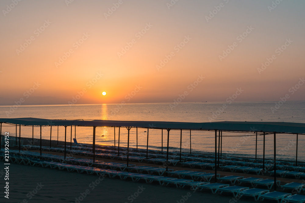 Beach in morning with sun loungers