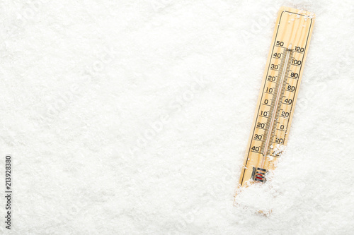 Wooden thermometer in white snow