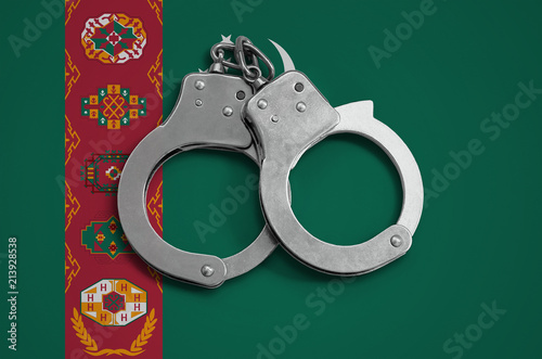 Turkmenistan flag  and police handcuffs. The concept of observance of the law in the country and protection from crime photo