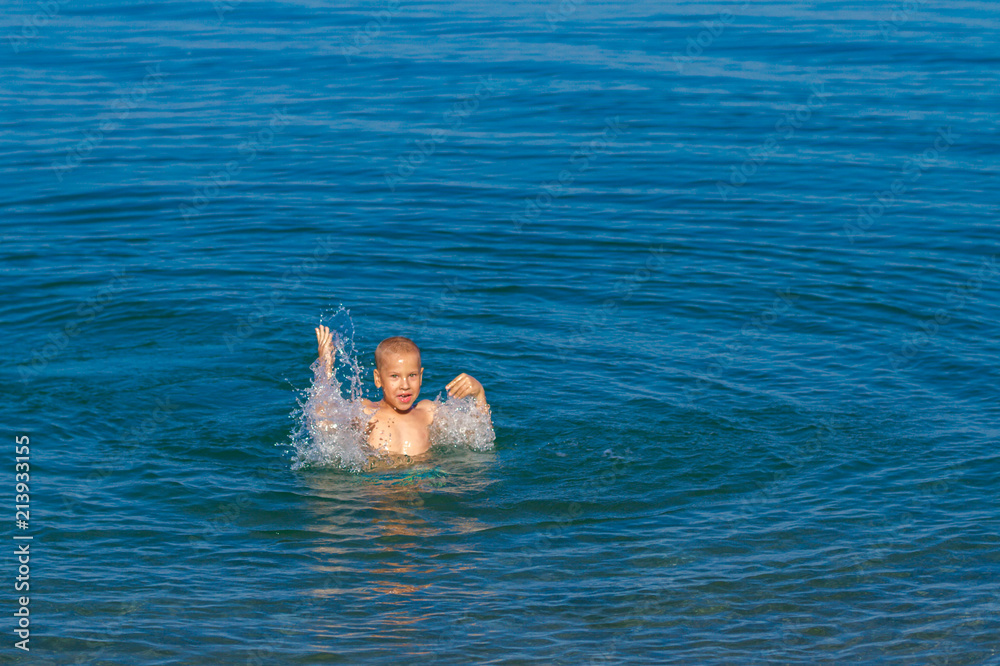 boy having fun and swimming in the sea