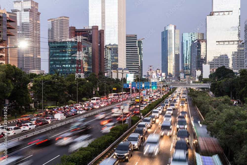 Rush hour traffic captured with blurred motion along the Gatot Subroto highway in the heart of Jakarta business district in Indonesia capital city at dusk