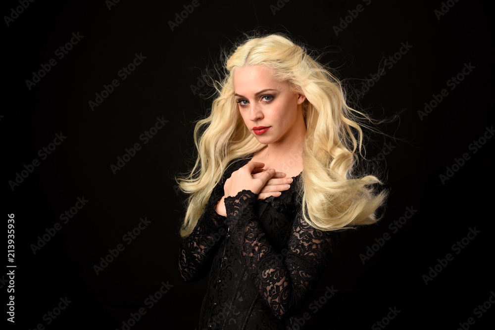 close up portrait of blonde woman wearing black lace gown. black studio background. close up portrait of blonde woman wearing black lace gown. black studio background.