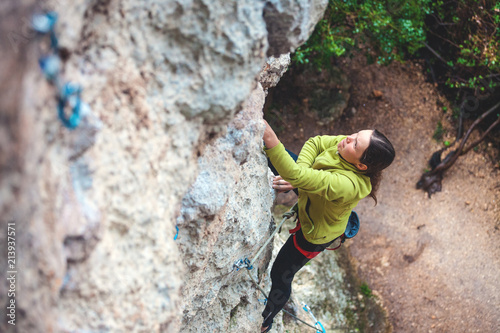 A woman climbs the rock.