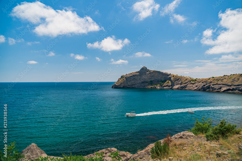 Blue sea with the rocky shore in the sunny afternoon Blue sea with the rocky shore in the sunny afternoon