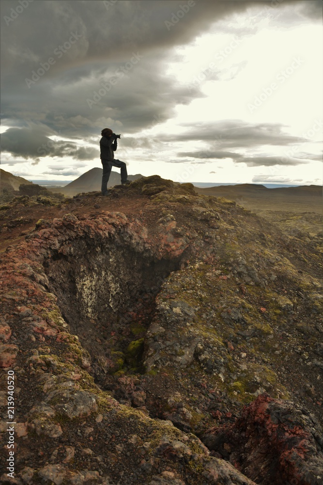 A photographer taking photos on the ruins of Krafla lava fields