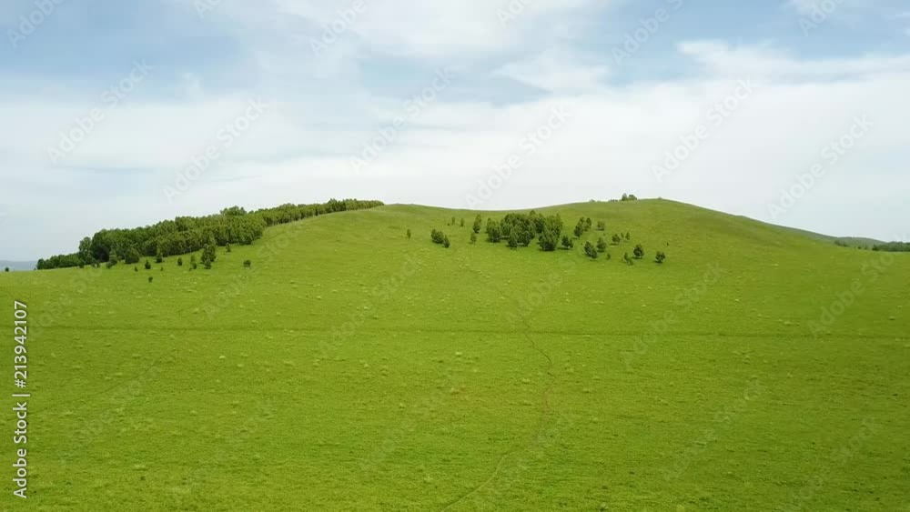 Over a small mountain on the grassland Over a small mountain on the grassland