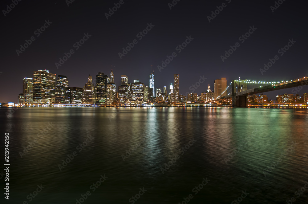 Colorful city lights at night from Brooklyn Bridge in New York City