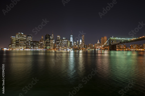 Colorful city lights at night from Brooklyn Bridge in New York City © el_cigarrito