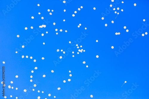 White balls flying in the blue sky