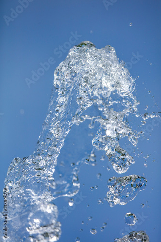 Splashing water with drops on the sky background