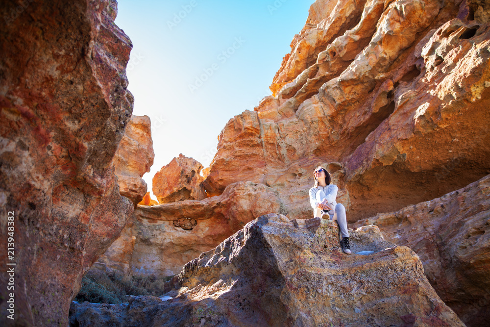 Traveler woman sitting on mountain in canyon