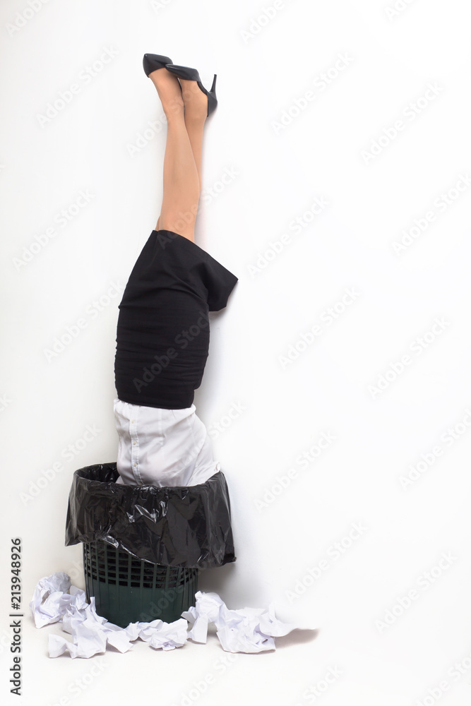 Female stuck in garbage bin upside down. Female office worker formaly
