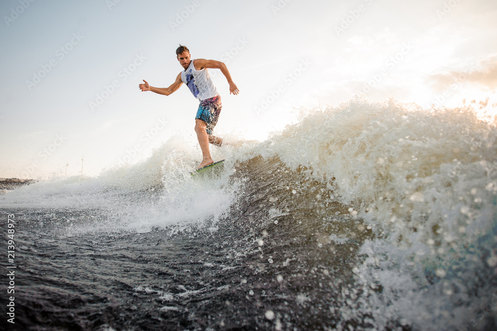 Fototapeta premium Athletic and young wakesurfer riding on river waves