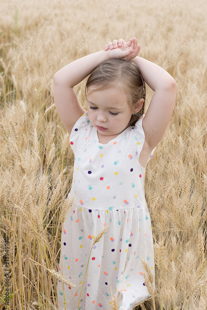 Enjoying the nature. Little girl stay in the golden wheat field Enjoying the nature. Little girl stay in the golden wheat field