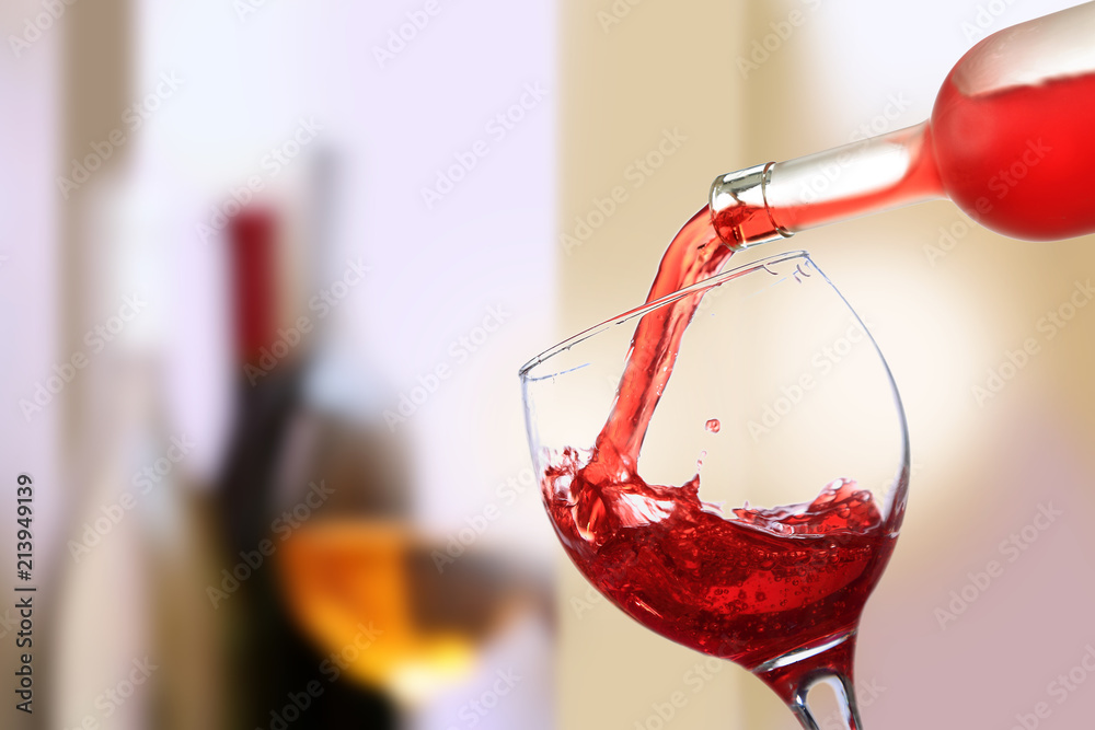 Obraz premium Wino czerwone wlewane do kieliszka, lampka do wino.
