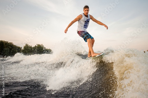 Active and strong wakesurfer riding down the river on board © fesenko