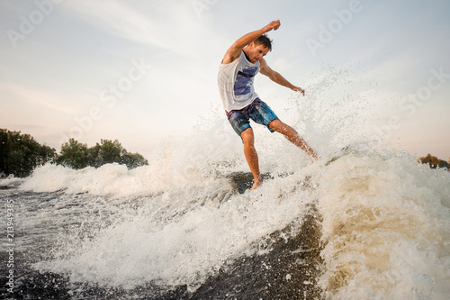 Young wakesurfer jumping and riding down the river on board © fesenko